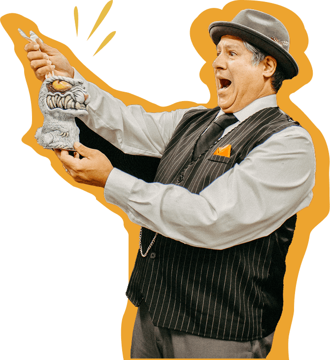 Frank Greer, a magician and entertainer in a vintage outfit, performing a lively magic act on stage with an animated expression and prop.