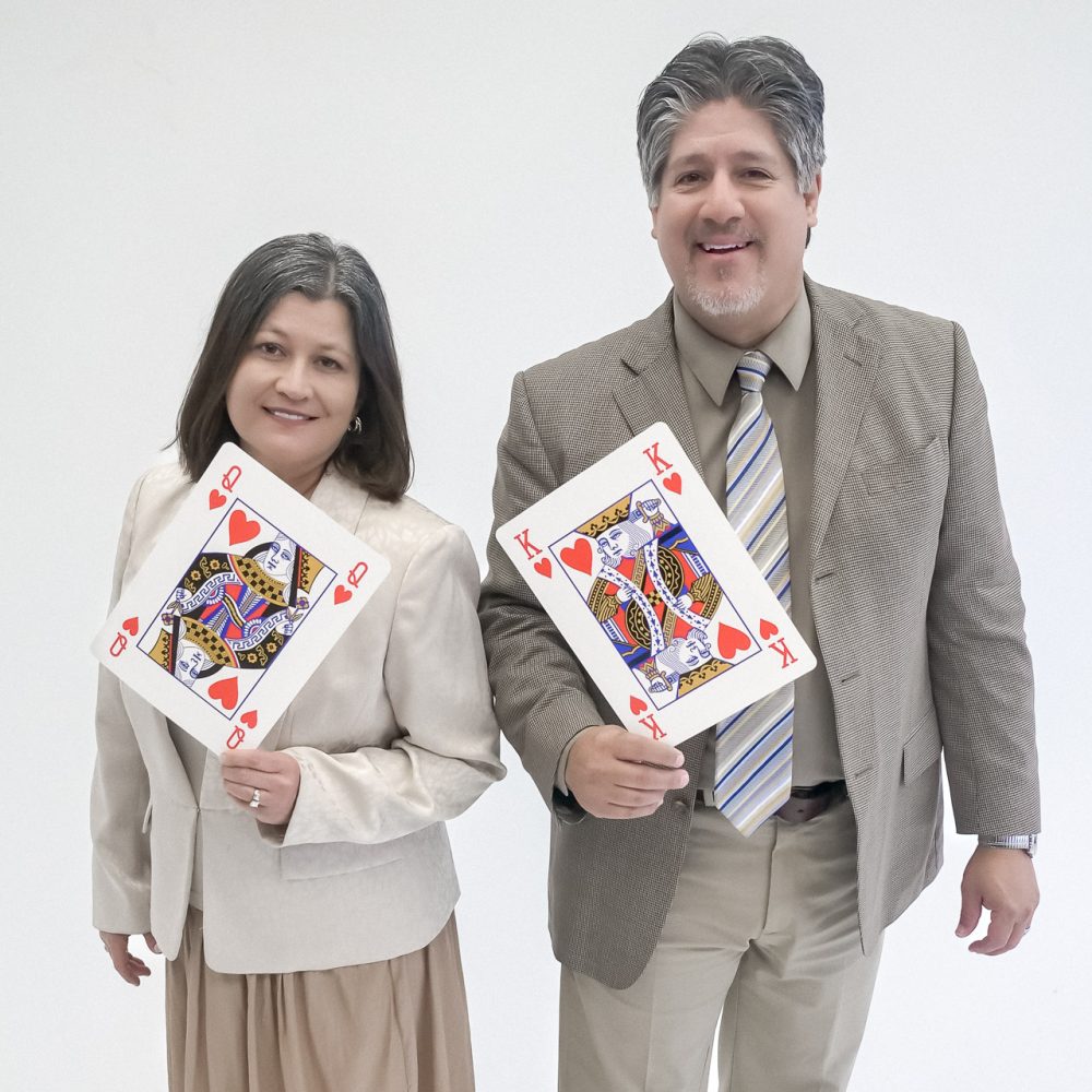 Frank and his wife holding large playing cards.