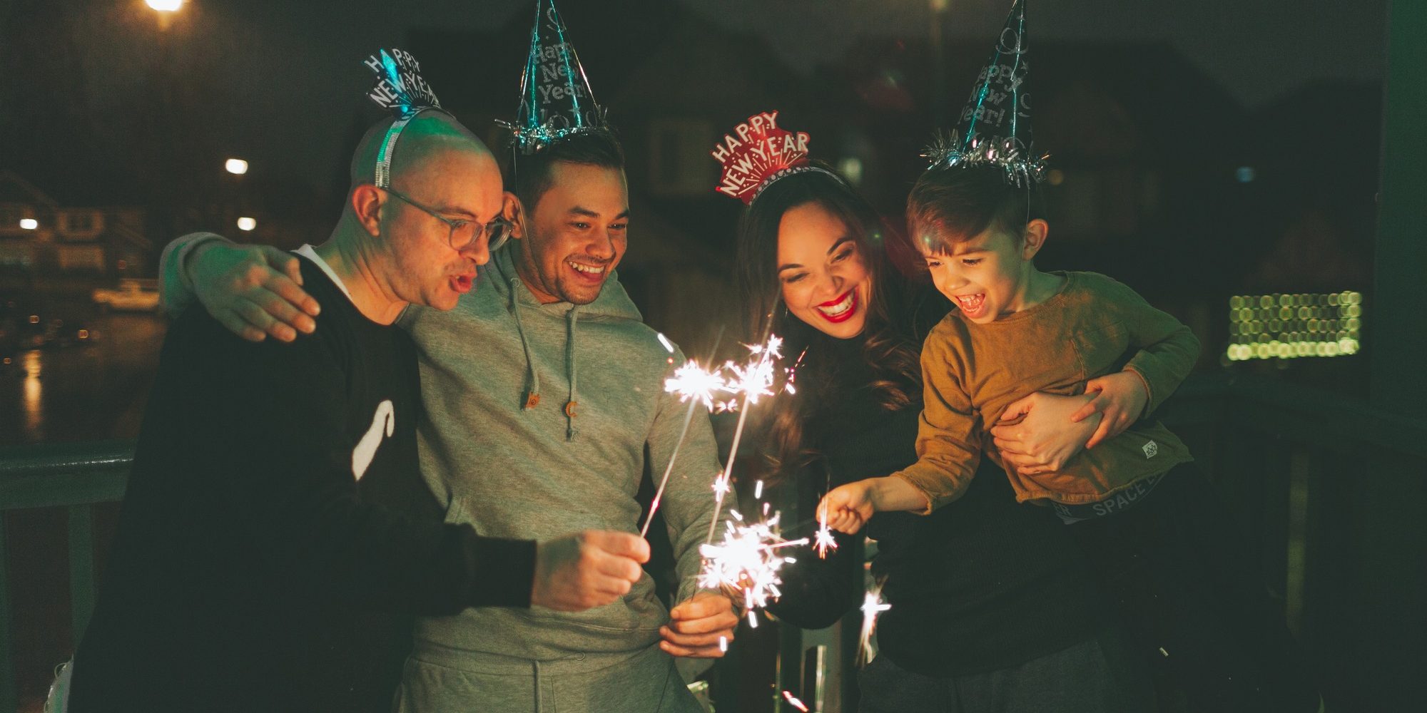Family holding sparklers on New Years Eve.